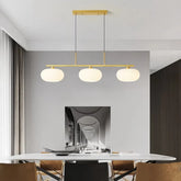 Pendelleuchte in Gold mit drei milchweißen Glasschirmen