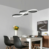 Schwarze LED-Pendelleuchte im Musiknoten-Design über einem Esstisch