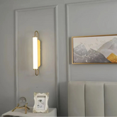 Goldene LED-Wandleuchte aus Metall mit Acryl-Diffusor im Schlafzimmer