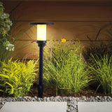 Warmweiß leuchtende Solar-Gartenleuchte am Gartenweg