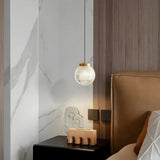 Glas-Pendelleuchte mit kugelförmigem Wabenschirm im Schlafzimmer