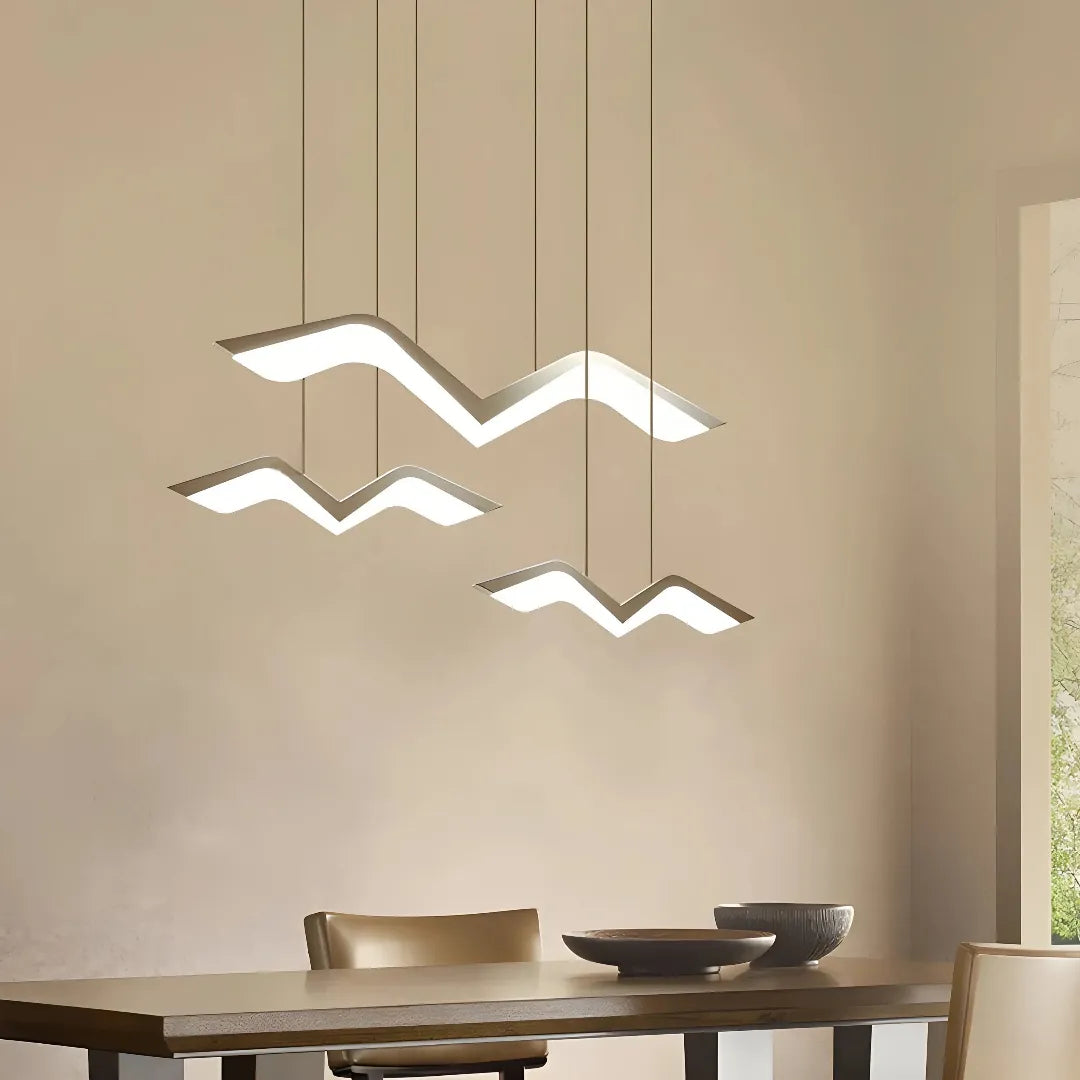 Weiße LED-Pendelleuchte mit Vogel-Silhouetten über einem Esstisch 