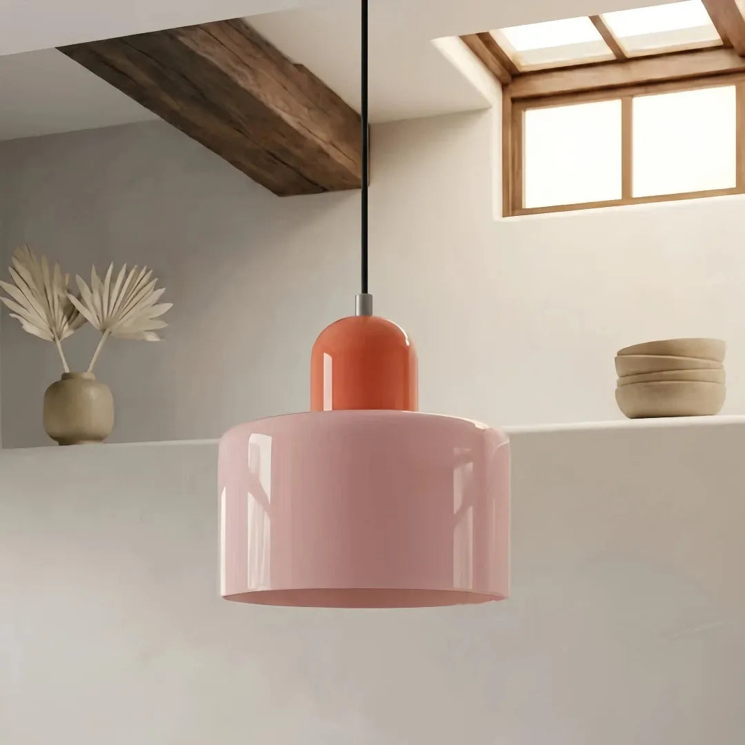  PendelleuchtRosa Glas-Pendelleuchte mit zylindrischem Lampenschirme aus rosa Glas im Bauhaus-Stil über dem Esstisch