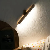 Schwenkbare Holz-Wandleuchte an der Wand über einem Bett