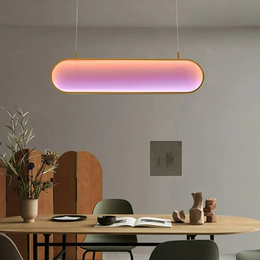 Ovale LED-Pendelleuchte in Gold über einem Esstisch