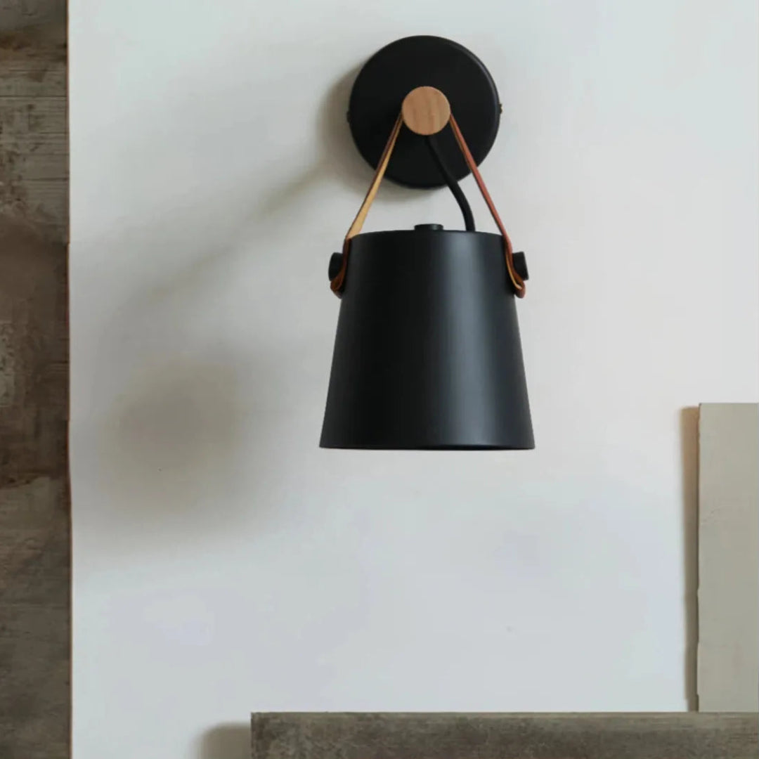 Schwarze Wandleuchte mit Holzhalterung an der Schlafzimmerwand